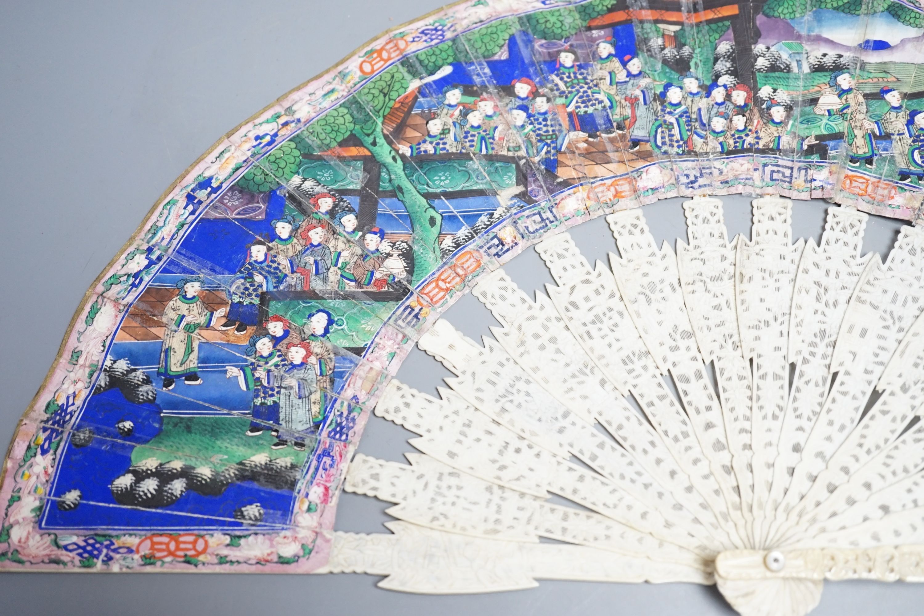 A 19th century Chinese export pierced ivory and painted paper leaf fan, in box. Fan 28cm long